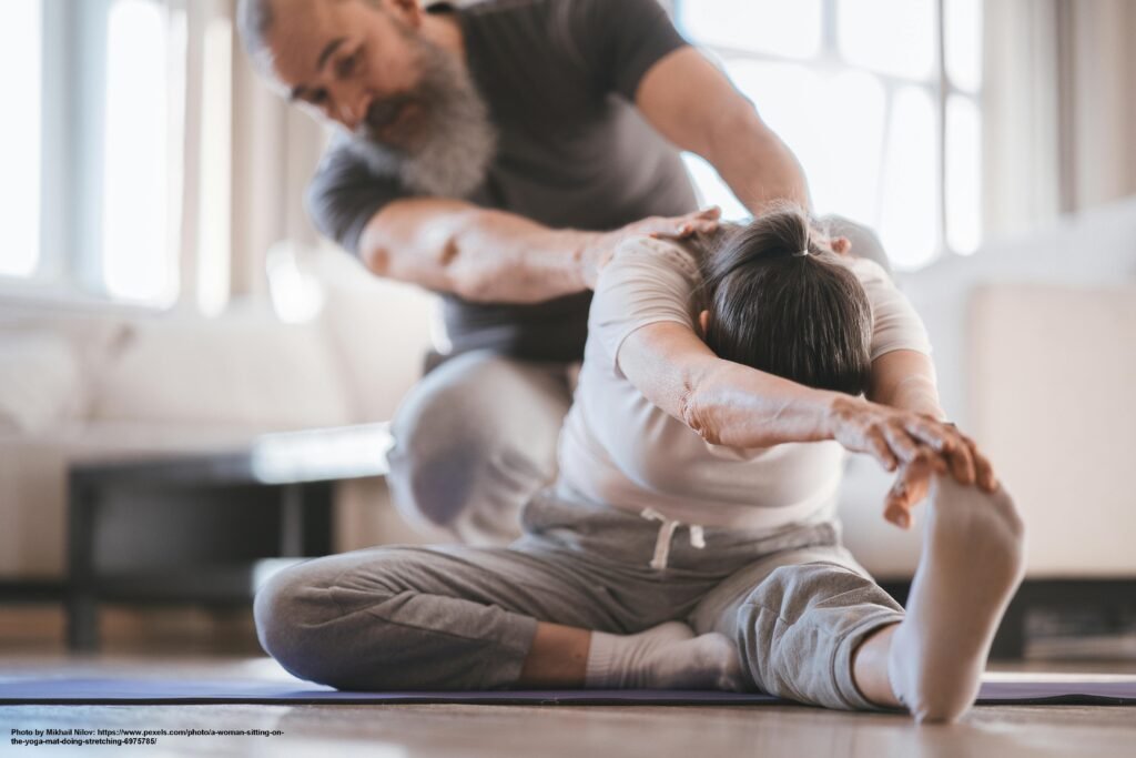 Two people performing a partner-assisted stretch in a well-lit room.