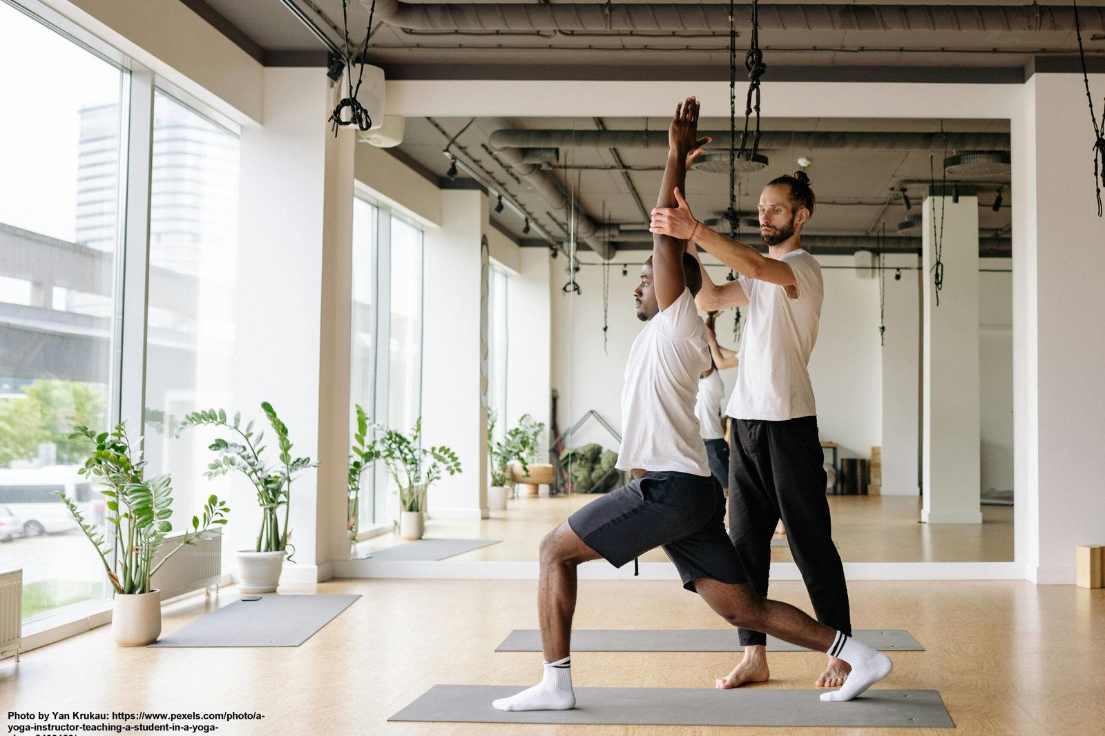Two people performing a partner-assisted stretch in a well-lit room.
