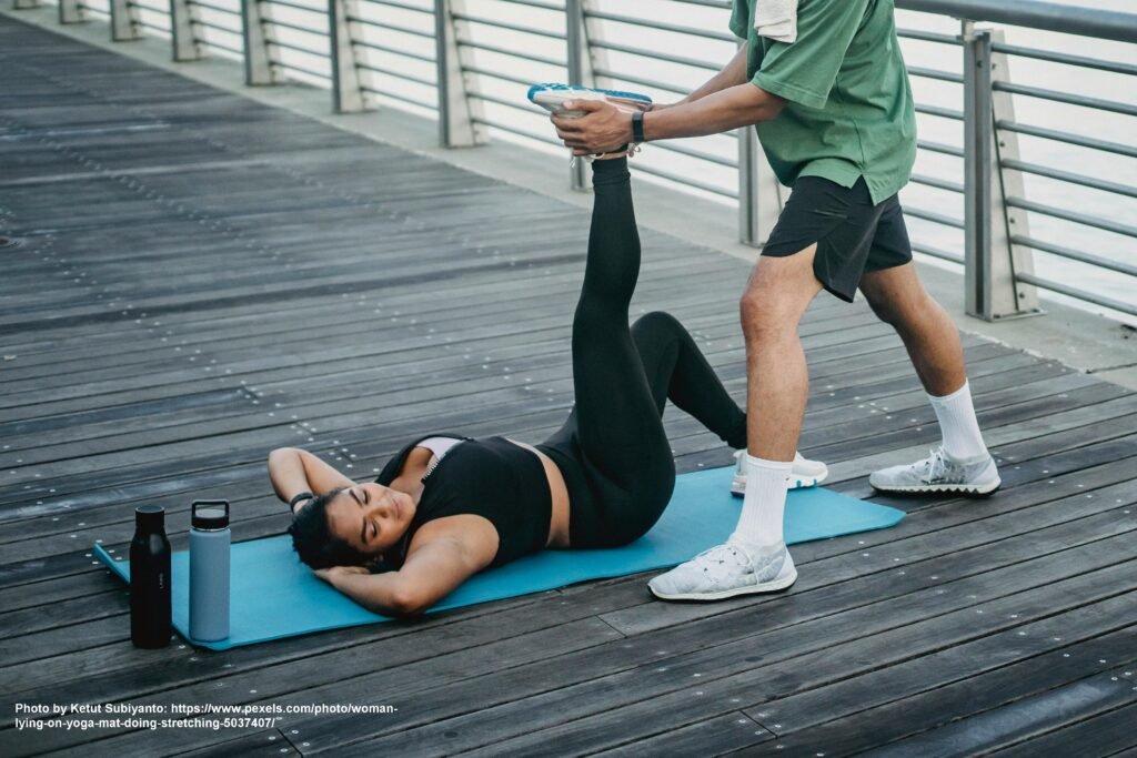 Two people performing a partner-assisted stretch in a well-lit room.
